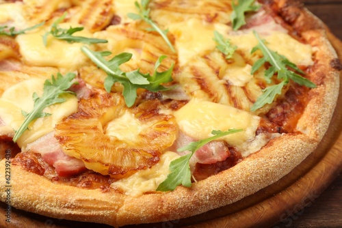 Delicious pineapple pizza with arugula on table, closeup