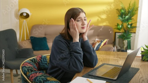 Nice young brunette going crazy while working on laptop at home in cosy room. Woman grabs her head in despair, can not find the source of inspiration. High quality 4k footage