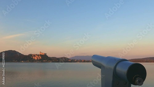 Binocular for watching Angera castle on Maggiore lake in Italy from Arona viewpoint at sunset photo