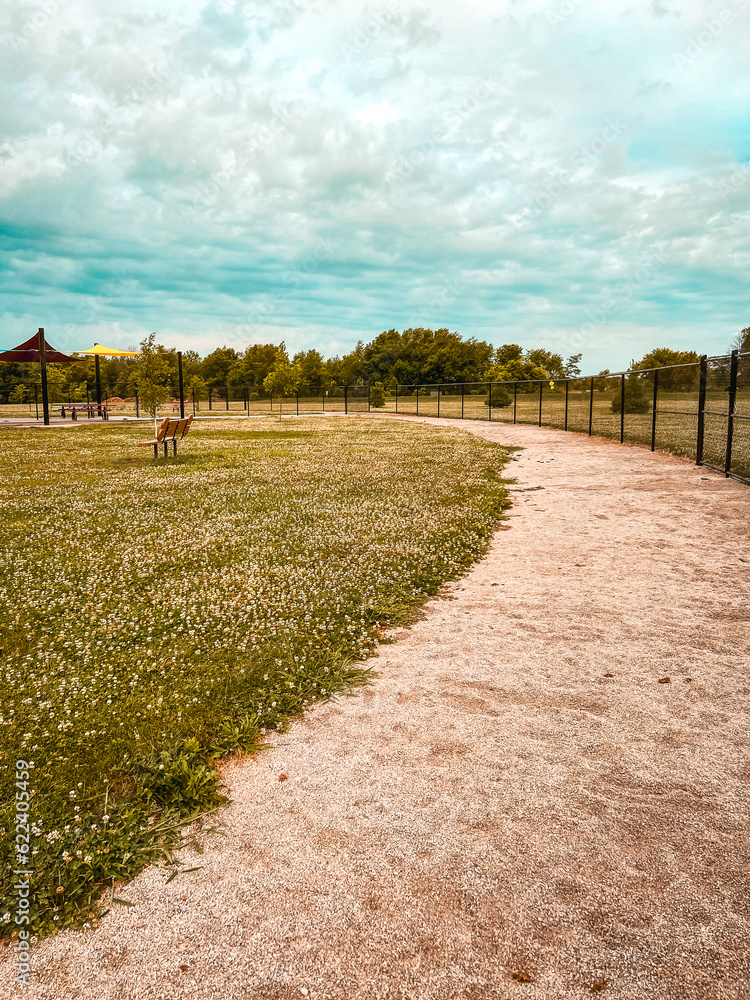 Curved Path in Enclosed Dog Park. Partial views of a circular trail