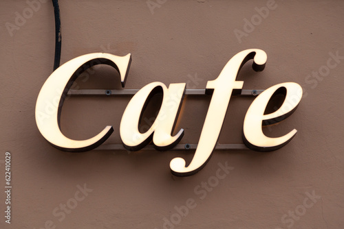 Inscription cafe in glowing white letters on wall....