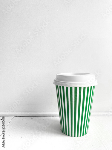 Green striped coffee cup, vertical photo. Street food coffee to go, closed plastic cup for various drinks and beverages on white background. Single object, take away (ID: 622410448)