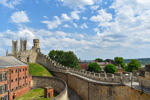 castle tower and walls ruins with english flag and blue skies and view of the city 