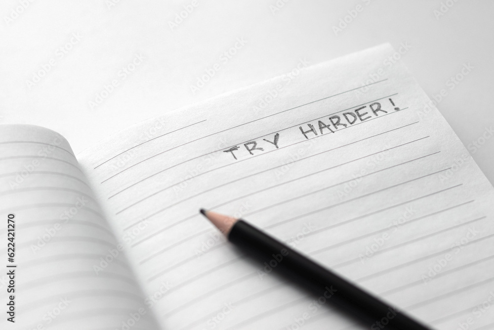 try harder - words of motivation are written in a notebook with a black pencil on a white background try harder - words of motivation are written in a notebook with a black pencil on a white background