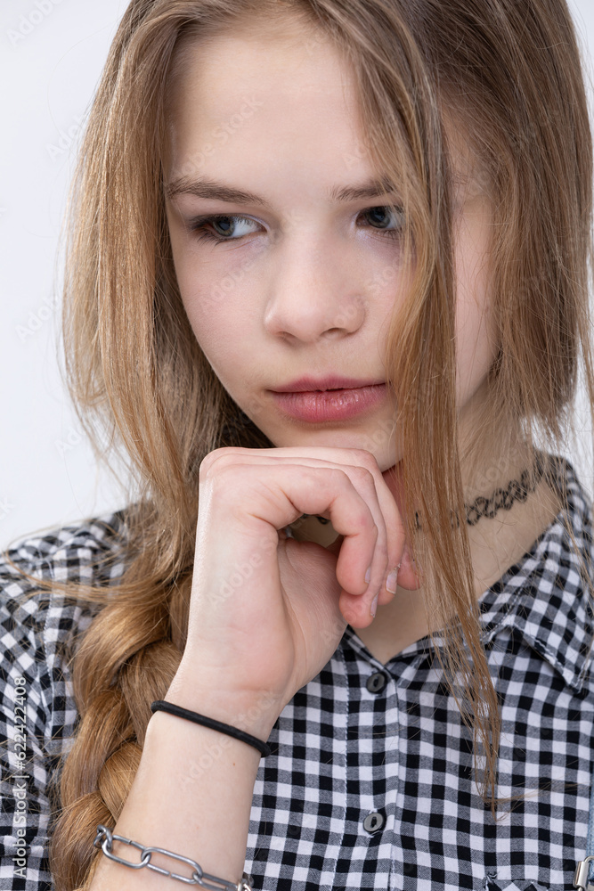 Close-up of the face of a thoughtful girl wearing a plaid shirt. Close-up of the face of a thoughtful girl wearing a plaid shirt.