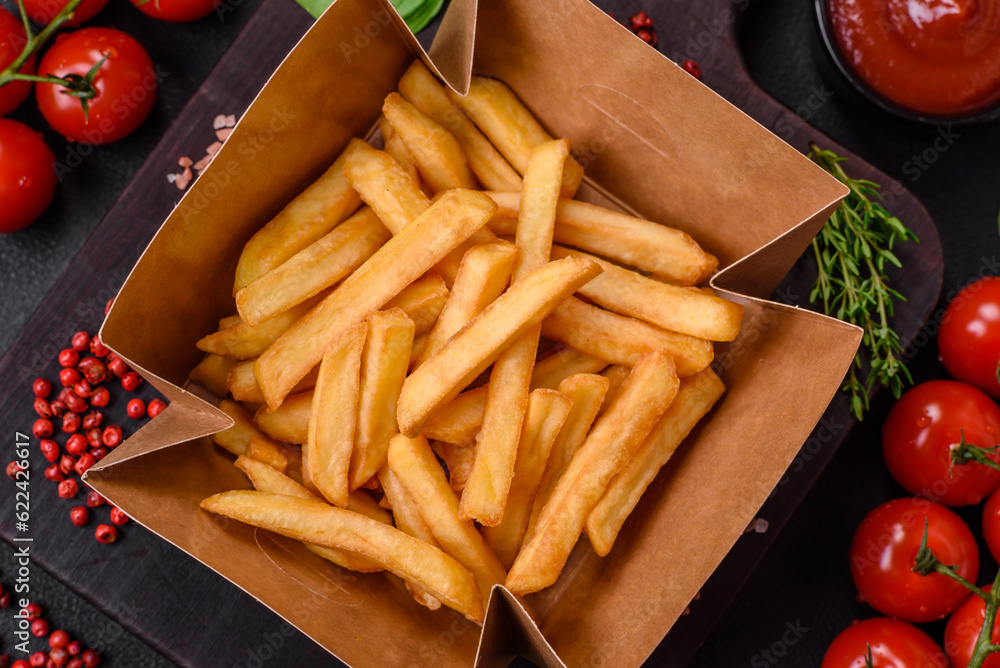 Delicious crispy french fries with salt and spices in a cardboard box Delicious crispy french fries with salt and spices in a cardboard box