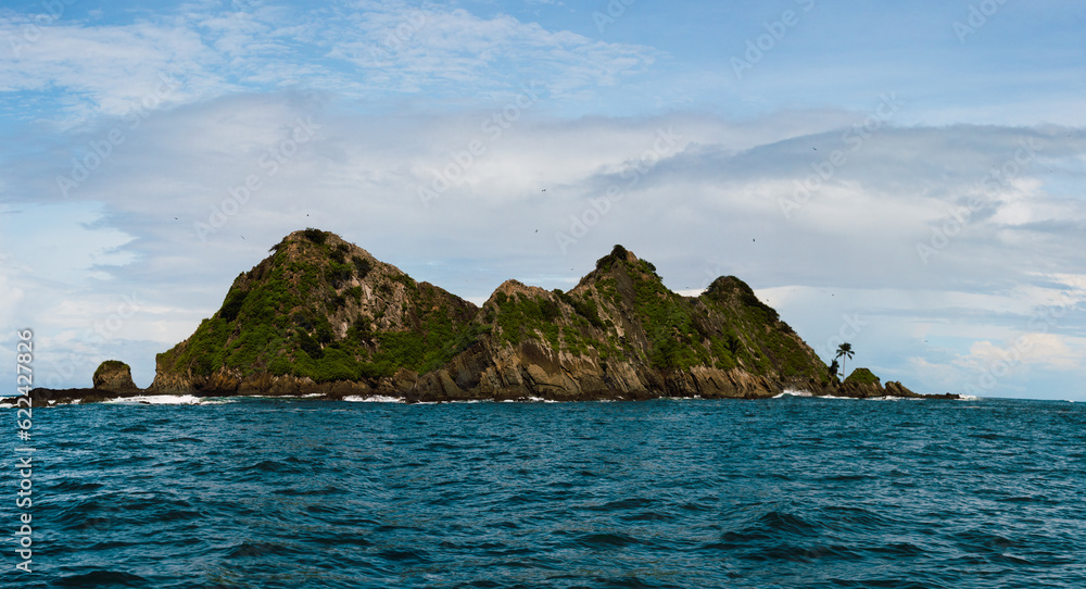 Rocky cliffs surrounded by rippling sea Rocky cliffs surrounded by rippling sea