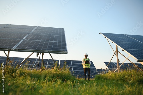 Quadro su tela Photovoltaic Green Energy Technology. Worker At Solar Panel Plant