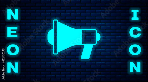 Glowing neon Megaphone icon isolated on brick wall background. Speaker sign. Vector photo