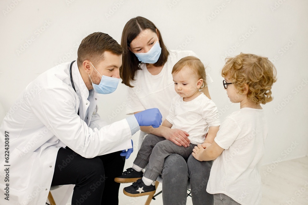 Obraz premium Mother and two her sons have an appointment with pediatrician