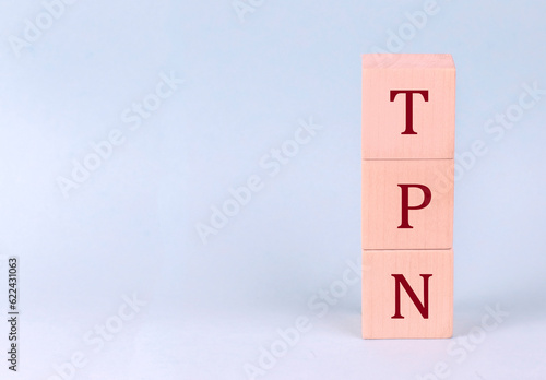 TPN - Total Parenteral Nutrition on wooden cubes on a blue background photo