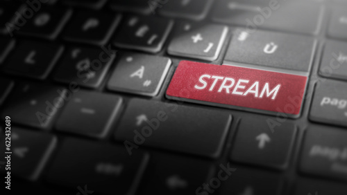 Stream key on laptop computer keyboard, red button on the dark grey keybord of a modern laptop notebook, broadcasting concept for live streaming and content creation, close-up