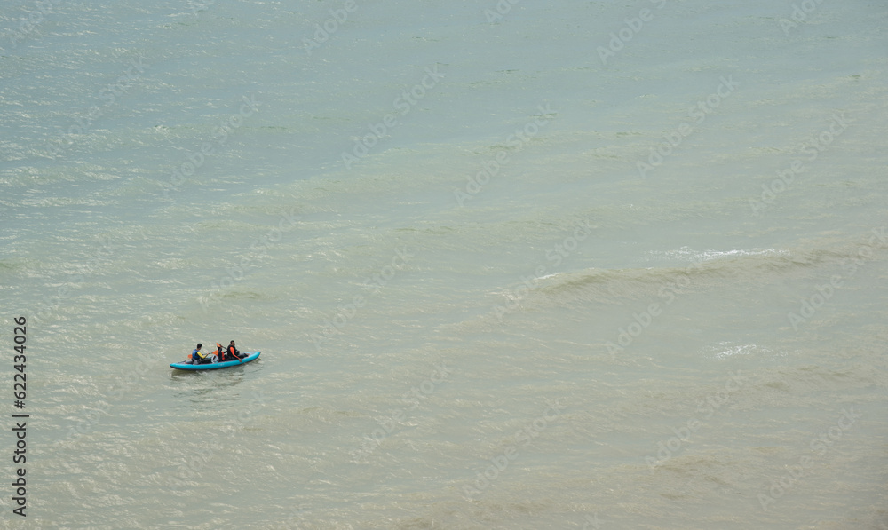 Unrecognized people canoeing in the sea in the morning. People exercising in the ocean Unrecognized people canoeing in the sea in the morning. People exercising in the ocean