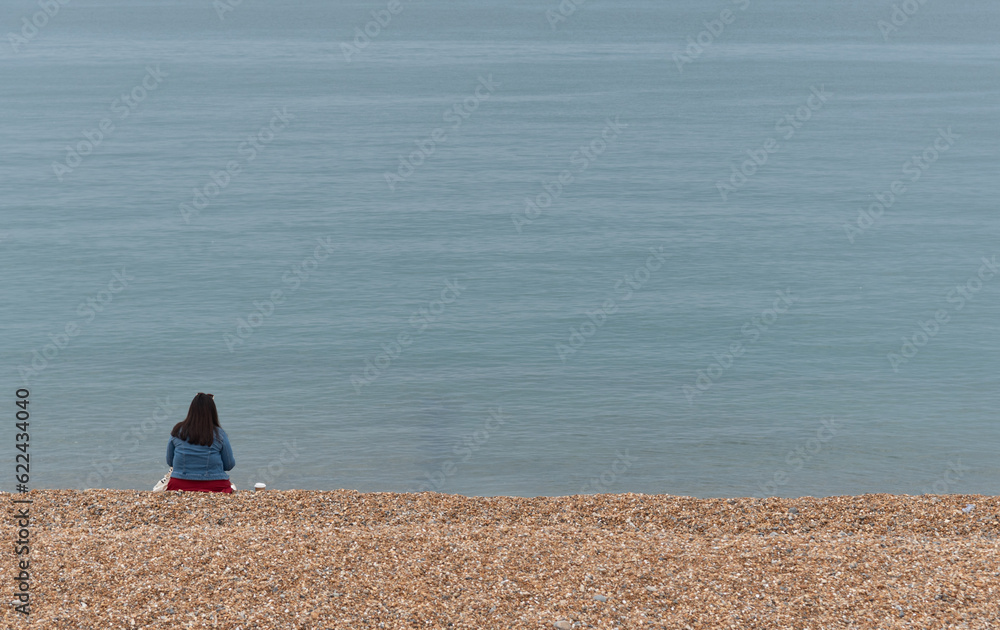 Person relaxing on a pebble beach. Summer holidays people leisure time Person relaxing on a pebble beach. Summer holidays people leisure time