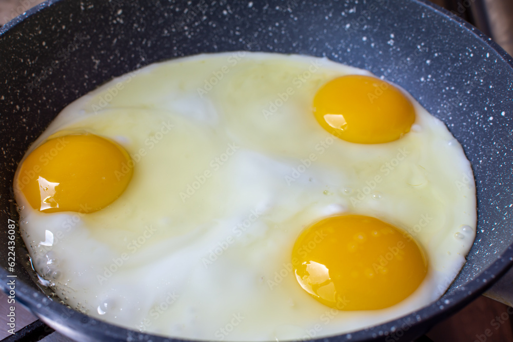 Three chicken eggs are fried in a frying pan Three chicken eggs are fried in a frying pan