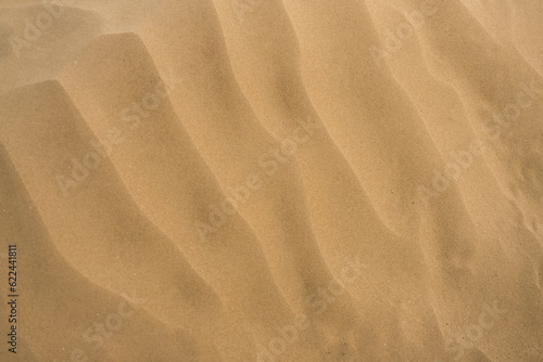 Minimalistic image of a sand dune in the desert with sand texture, in cloudy weather in summer