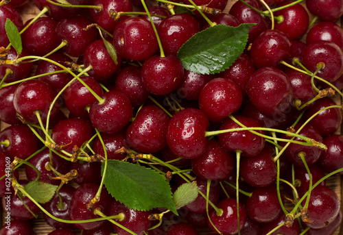 Fresh cherry with leaves as backgroung, top view © Liami