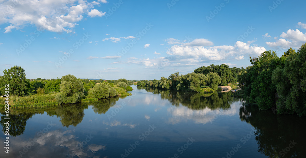 Panorama rzeki Odry w tle lekko pochmurna pogoda, błękit nieba zieleń przy brzegu, pora letnia, Odra w odcinku województwa Opolskiego	
