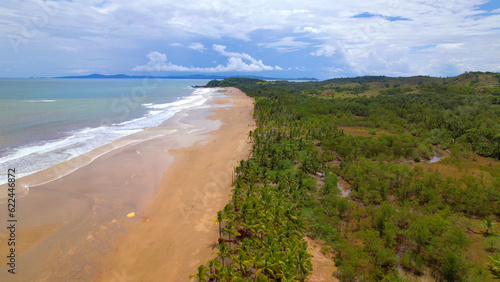 AERIAL: Magnificent sandy beach between lush palm trees and blue Pacific ocean