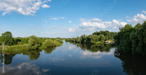 Panorama rzeki Odry w tle lekko pochmurna pogoda  b    kit nieba ziele   przy brzegu  pora letnia  Odra w odcinku wojew  dztwa Opolskiego 