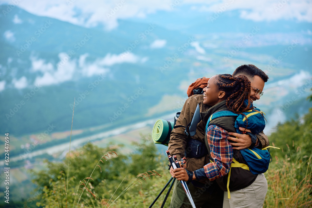 Happy couple of backpackers embracing on top of mountain. Happy couple of backpackers embracing on top of mountain.