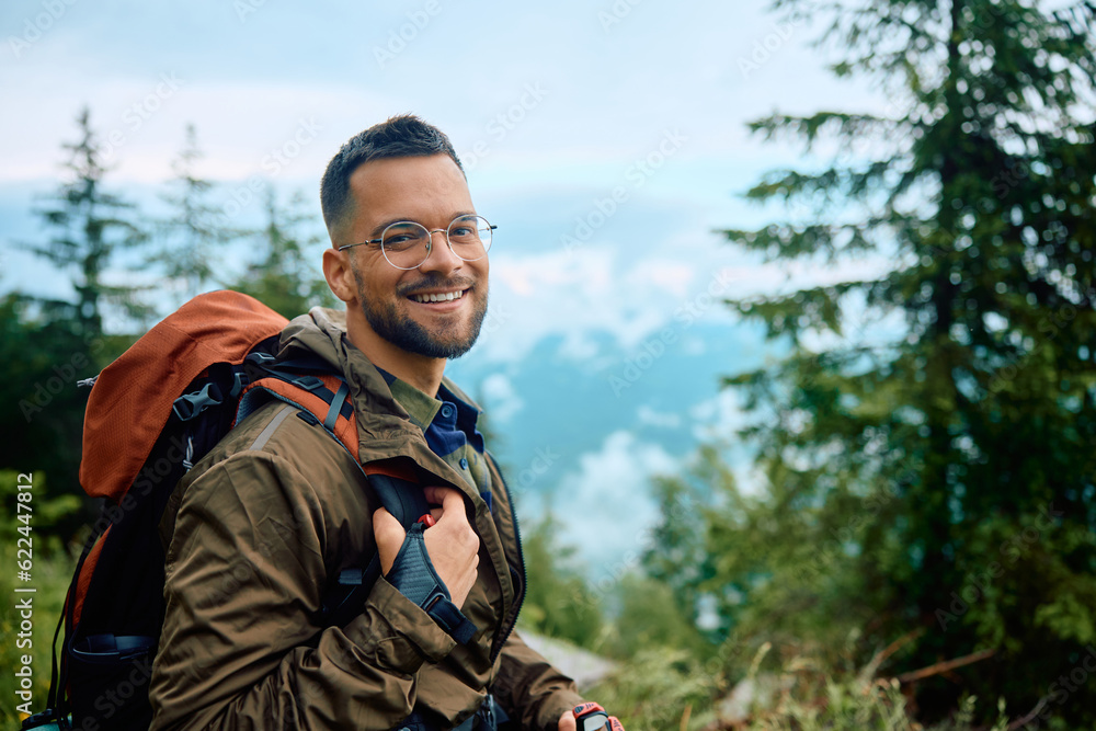 Young happy man hiking in nature and looking at camera.