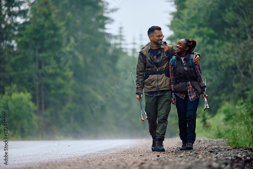 Embraced couple of hikers enjoy in walk by road in nature.