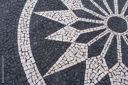 Portuguese traditional black and white pavement made from calcada tiling. Fragment of sidewalk paving in Funchal, Madeira island