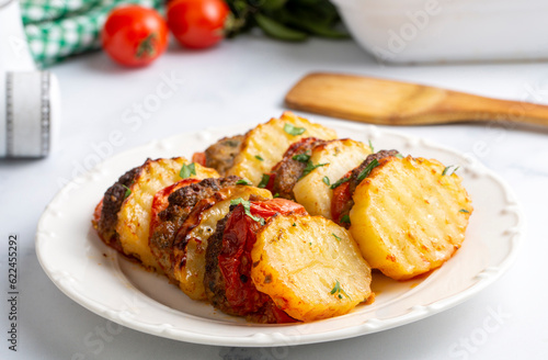Traditional Turkish food; baked potatoes and meatballs. Turkish name; kofteli patates dizmesi, patates dizme photo