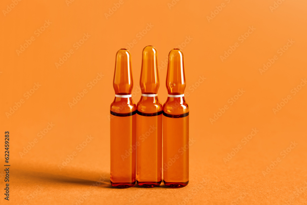 Glass ampules on orange background Glass ampules on orange background