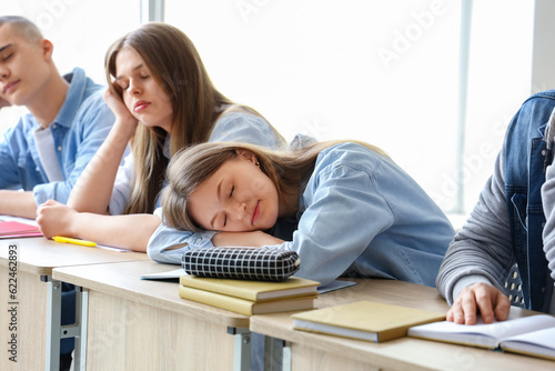 Tired sleepy classmates sit...