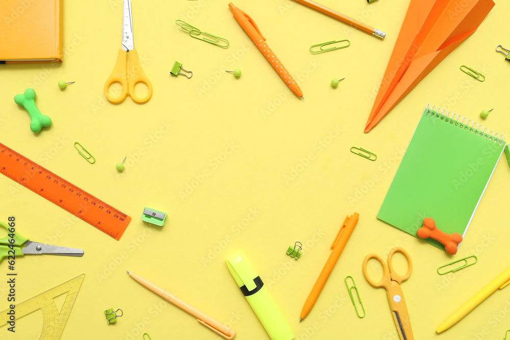 Frame made of paper plane and different school stationery on yellow background Frame made of paper plane and different school stationery on yellow background