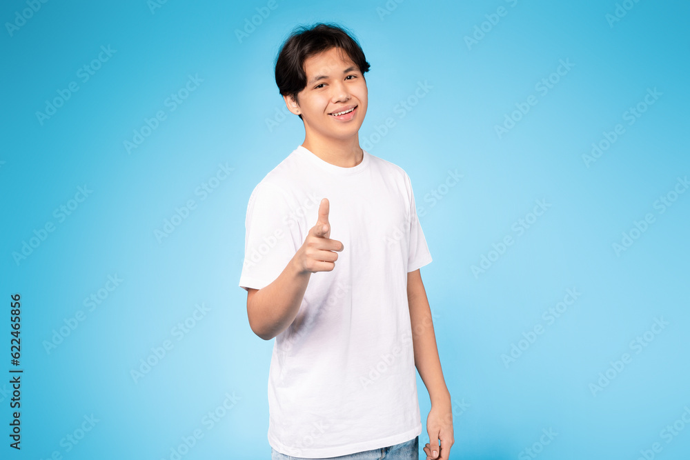 Japanese Teen Guy Pointing Finger At Camera Over Blue Background Japanese Teen Guy Pointing Finger At Camera Over Blue Background