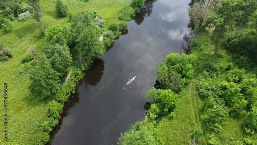 Canoeing on a quiet river in a picturesque area. Drone view of that beautiful river with green banks. Canoeing on a quiet river in a picturesque area. Drone view of that beautiful river with green banks.