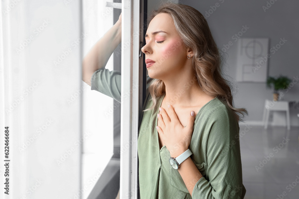 Young woman having panic attack near window Young woman having panic attack near window