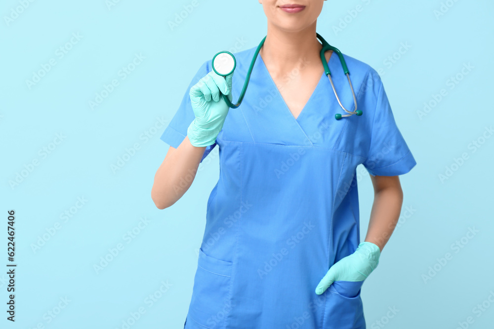 Female doctor with stethoscope and medical gloves on blue background Female doctor with stethoscope and medical gloves on blue background