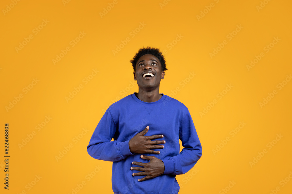 Joyful millennial black man laughing and looking up Joyful millennial black man laughing and looking up