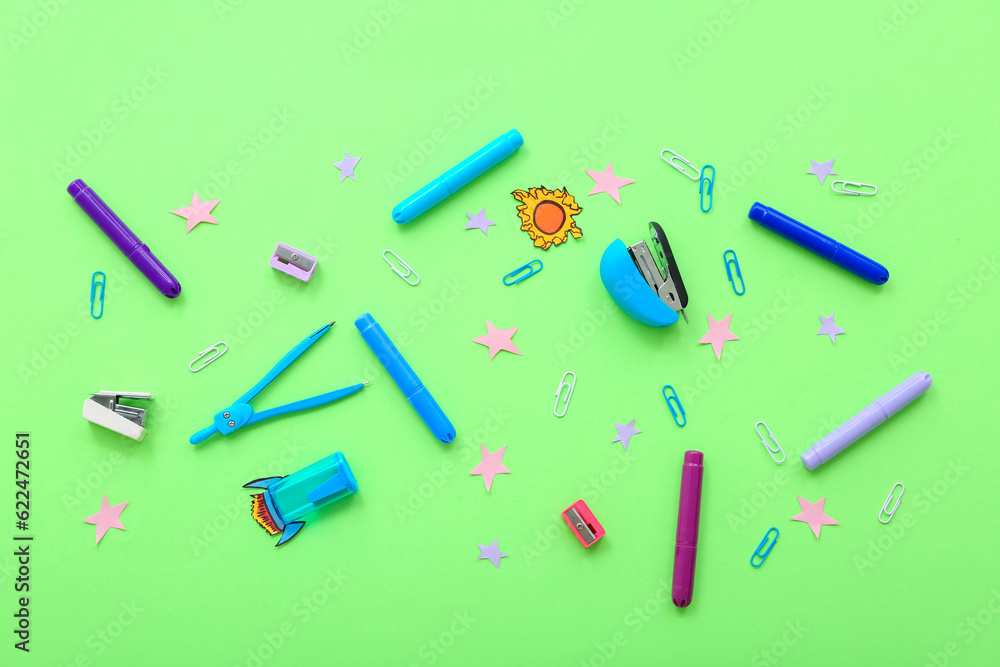 Creative composition with paper rocket, stars and different stationery on green background Creative composition with paper rocket, stars and different stationery on green background