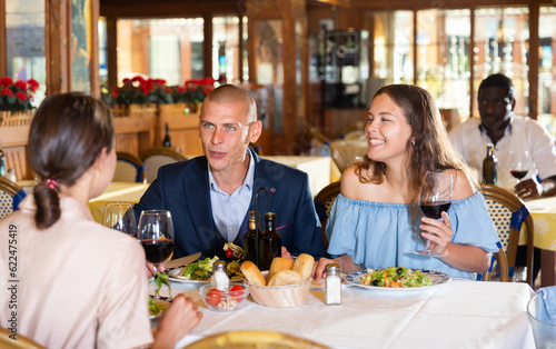 Group of friends dining together at restaurant  laughing  talking and having fun