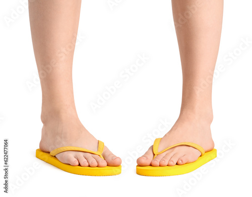 Female legs in flip-flops on white background