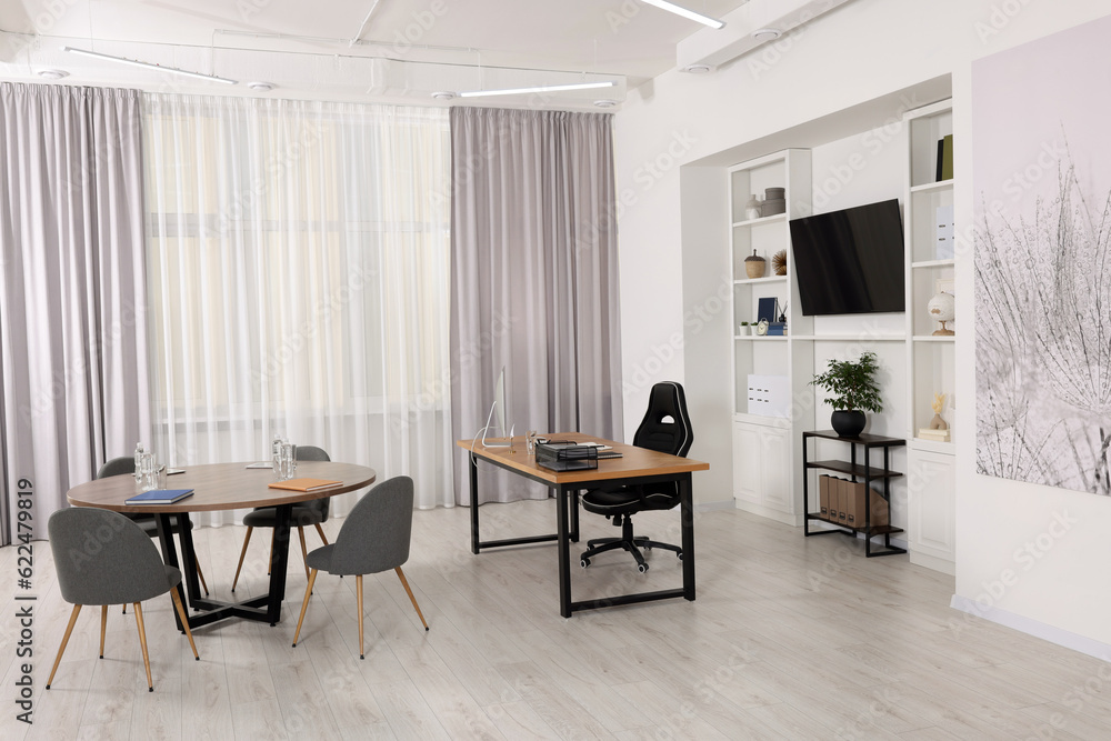 Fototapeta premium Stylish director's workplace with comfortable furniture and tv zone in room. Interior design