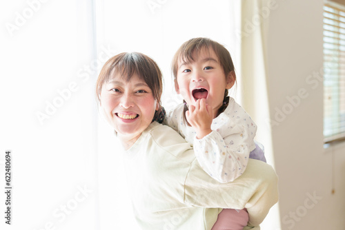 女の子をおんぶするお母さん