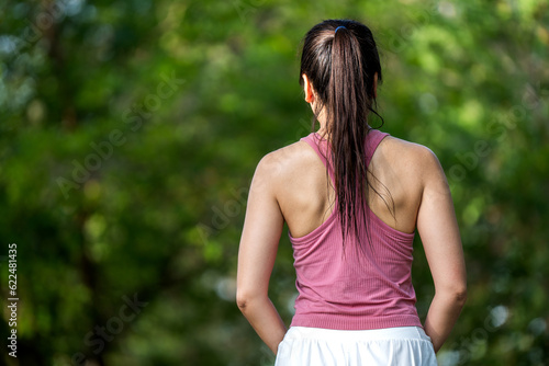 Healthy Asian woman in sports outfits doing stretching before workout running exercise outdoors in the park in the morning