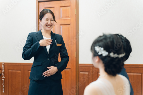 Fotografi 結婚式場・ホテルで働くスーツ姿のコンシェルジュ・ホテルマン・ホテリエ・ウェディングプランナーの女性