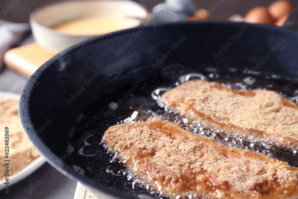Cooking schnitzels in frying pan, closeup view Cooking schnitzels in frying pan, closeup view