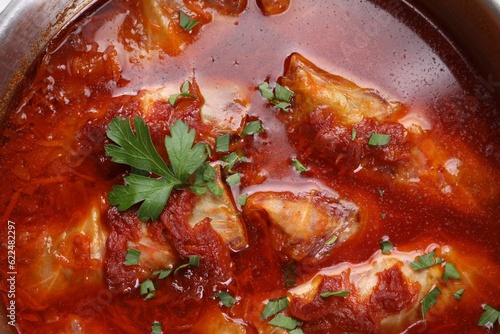 Delicious stuffed cabbage rolls cooked with homemade tomato sauce in pot, top view