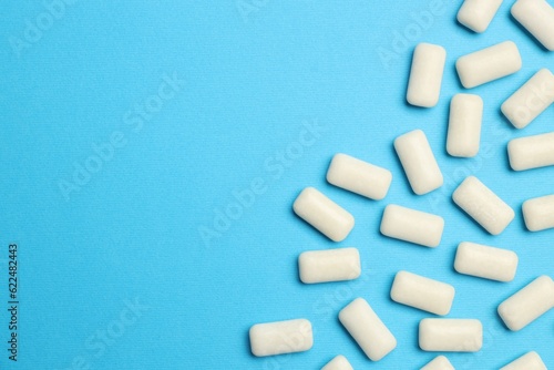 White bubble gums on blue background, flat lay. Space for text