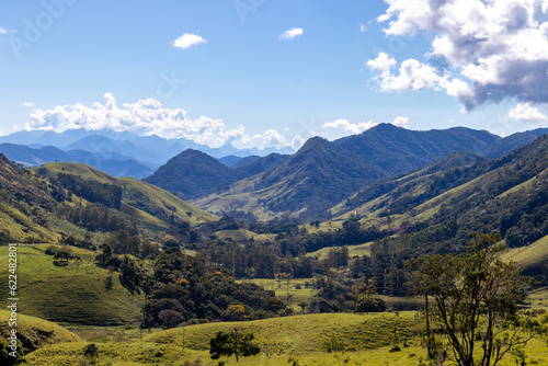 Panorama of mountainous terrain with forest and small houses. Panoramic view of vast expanses of mountain ranges and large ranges on the horizon. Immense distances of wavy relief. Rio de Janeiro