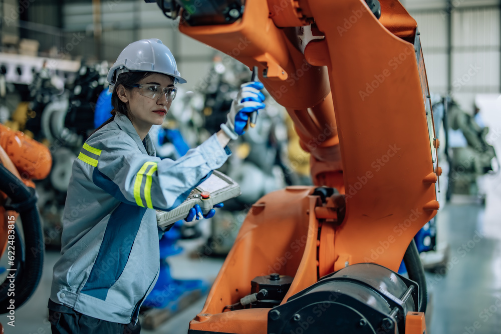 Robotic technician uses control panel to operate, maintain robotic arm in factory. Ensuring productivity, efficiency, and safety through monitoring, analyzing database, and integrating processes. Robotic technician uses control panel to operate, maintain robotic arm in factory. Ensuring productivity, efficiency, and safety through monitoring, analyzing database, and integrating processes.