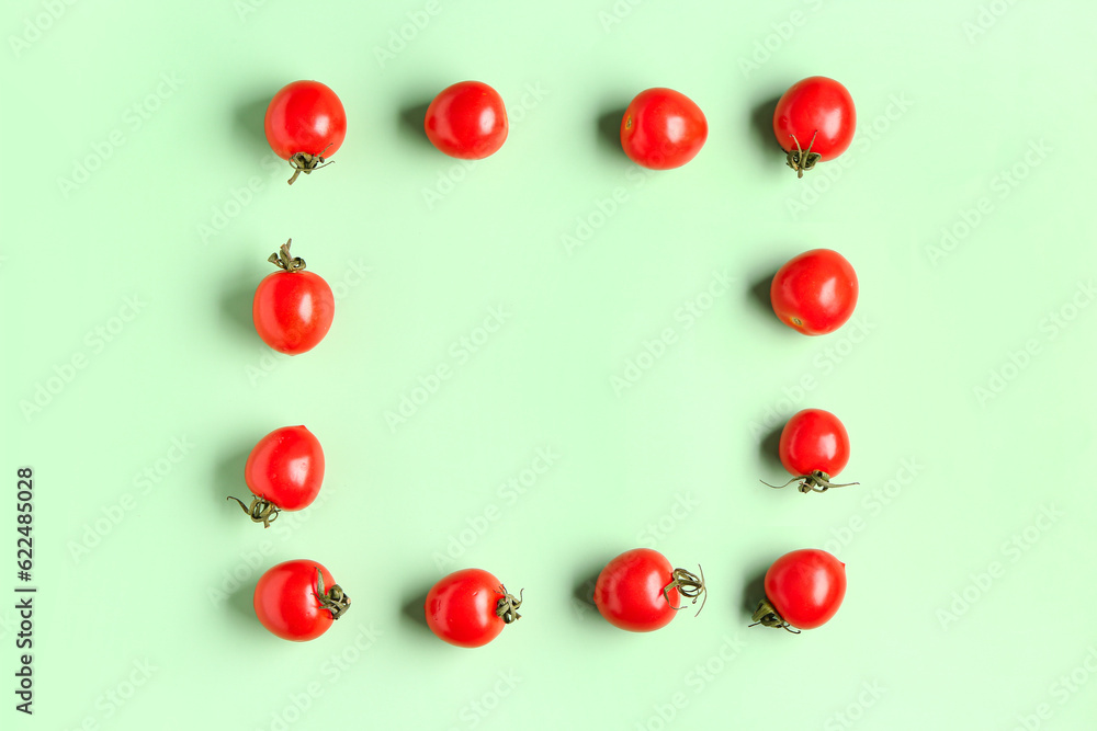 Frame made of fresh cherry tomatoes on green background Frame made of fresh cherry tomatoes on green background